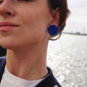 circle earrings blue on person at seaside